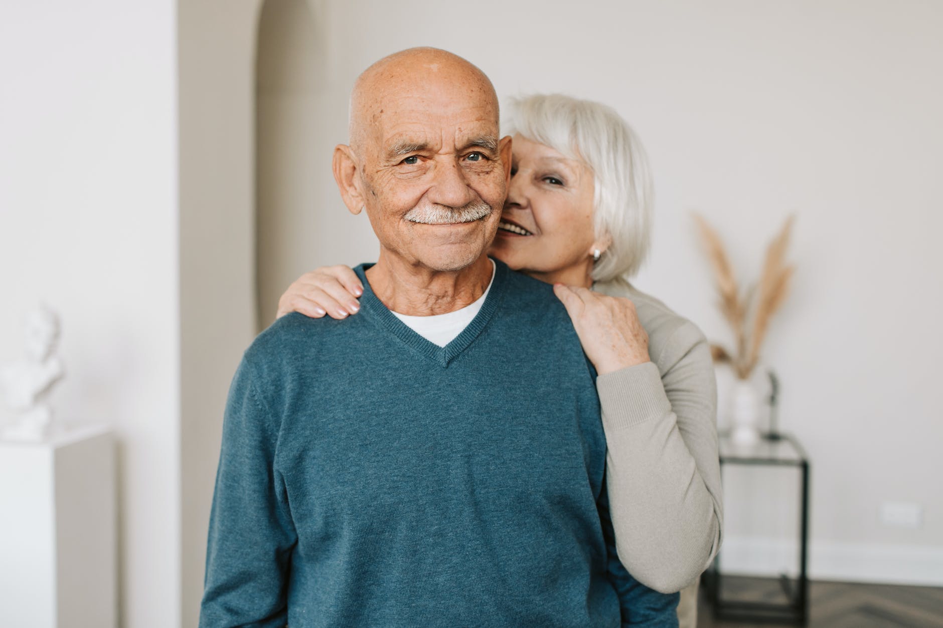 man in blue v neck sweater and a woman in brown long sleeve shirt